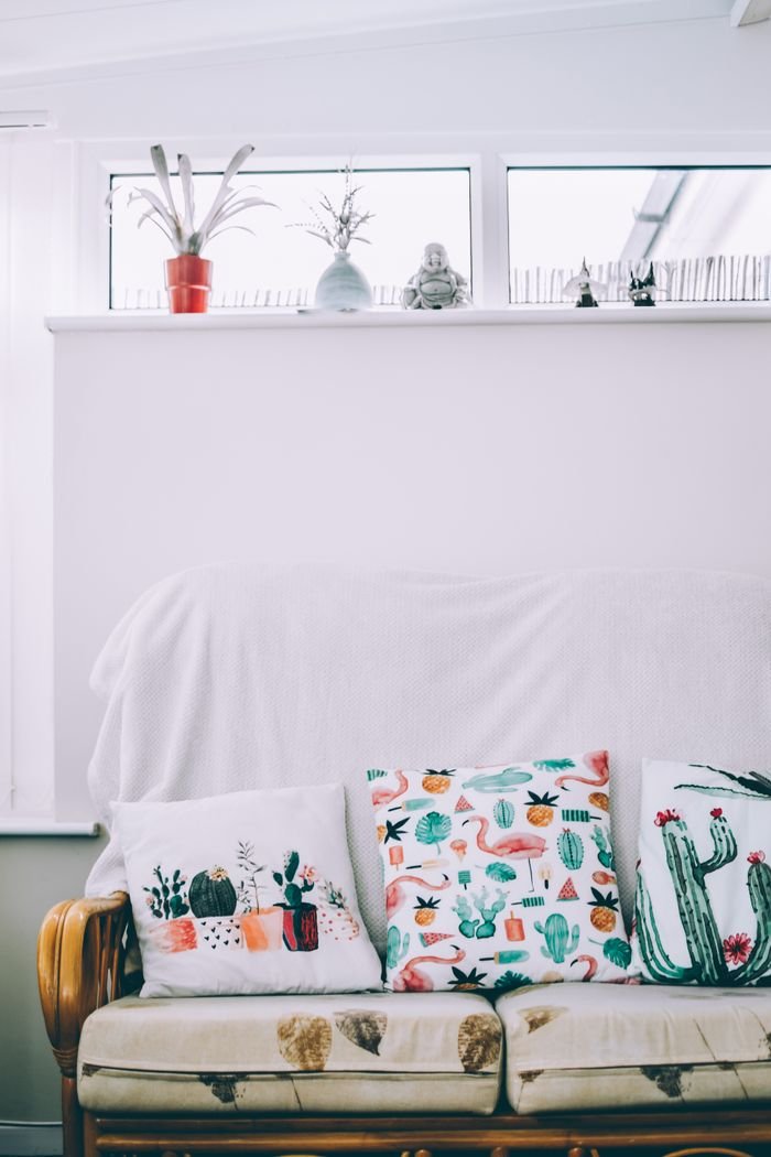 The Art of Drawing Readers In: Your attractive post title goes here A cozy living room with cactus-themed throw pillows, a white sofa, and modern decor.