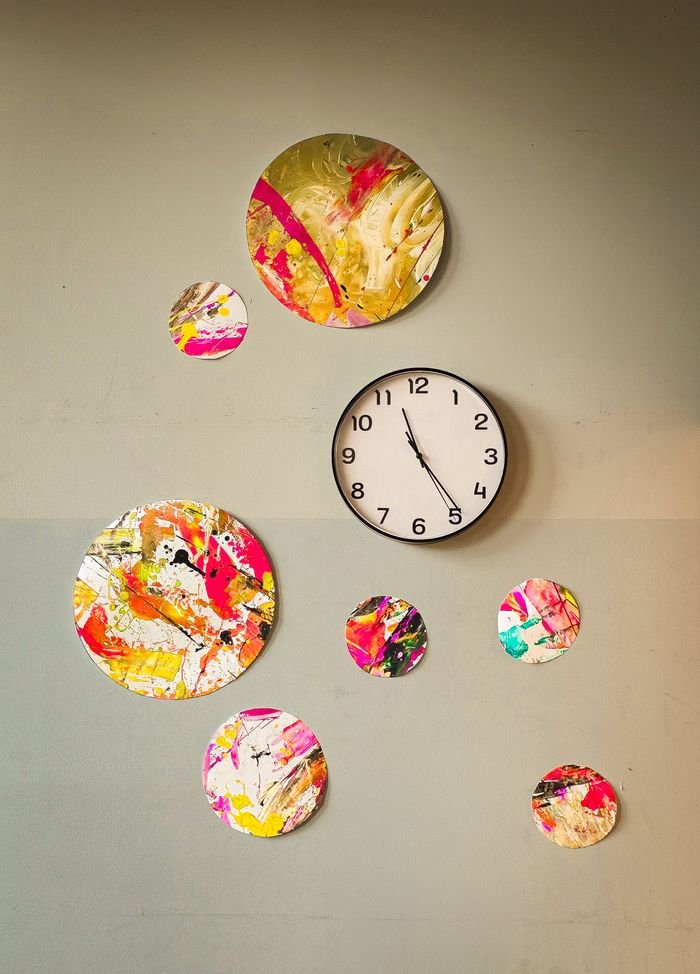 Crafting Captivating Headlines: Your awesome post title goes here Wall clock surrounded by colorful abstract decor on a light wall, creating a modern artistic feel.